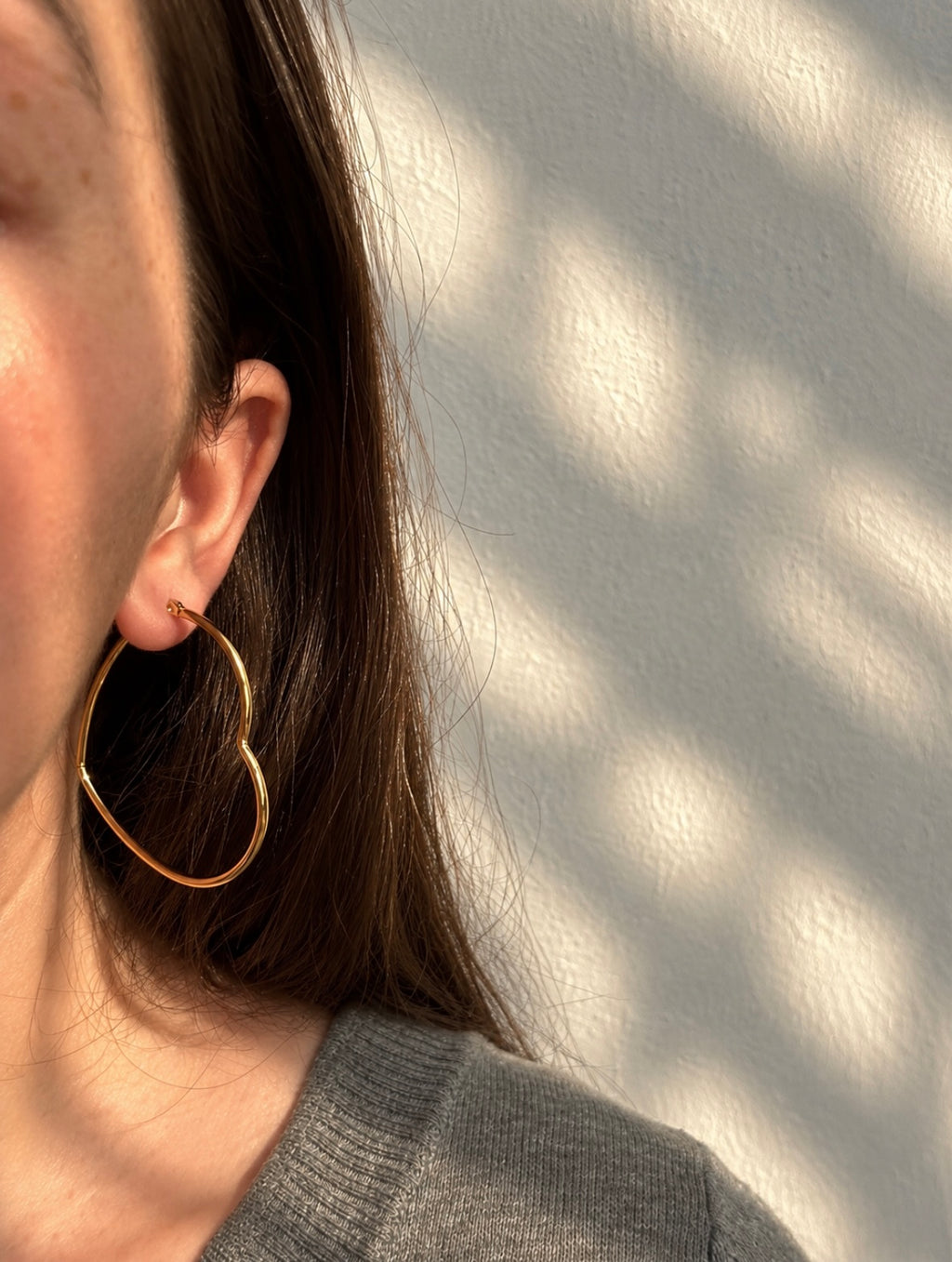 Amora Hoops – gold heart-shaped hoop earrings worn