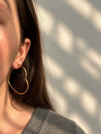 Amora Hoops – gold heart-shaped hoop earrings worn