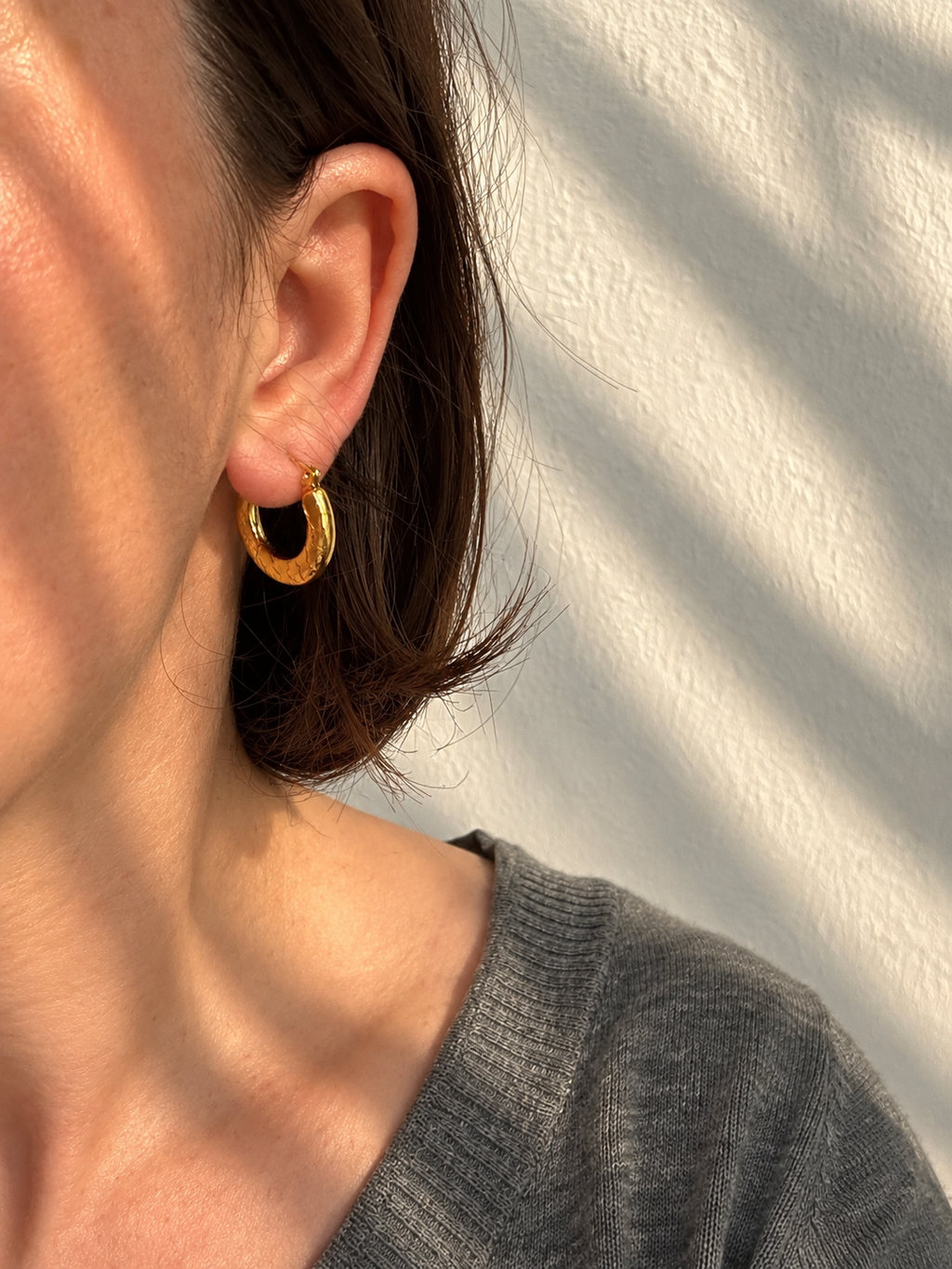 Ciria Earrings – gold textured hoops worn