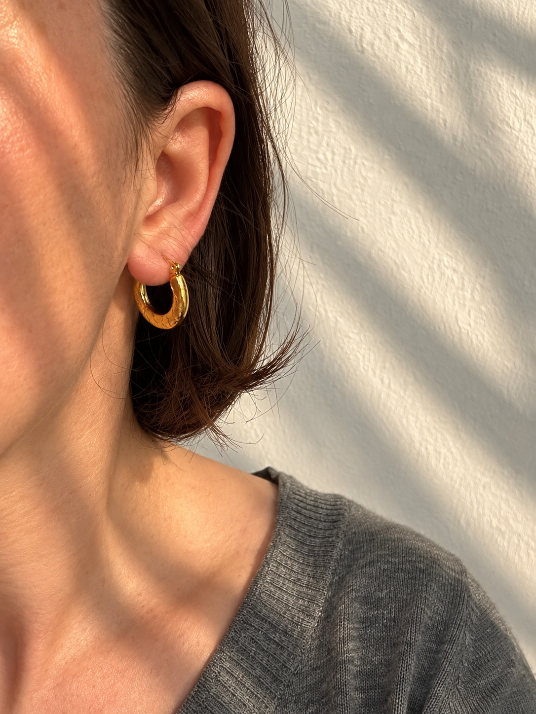 Ciria Earrings – gold textured hoops worn