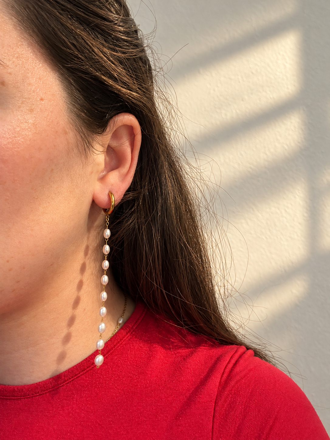 Soreina gold pearl-look earrings worn